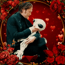 a man is holding a stuffed animal surrounded by roses and hearts