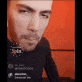 a man with a beard is making a funny face while sitting in front of a red wall .