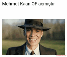a man wearing a hat and a suit is smiling with the words mehmet kaan of acmistir above him