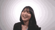 a woman is smiling with her eyes closed