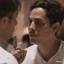 two men are looking at each other and one is pointing at the other