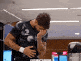 a man covering his face with his hands in a gym with the words chosentoshine on the bottom