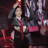 a woman in a suit and tie is singing into a microphone on stage