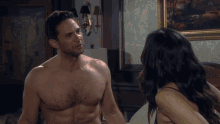 a man without a shirt is talking to a woman