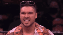 a man wearing sunglasses and a shirt that says aew on the bottom