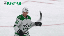 a hockey player wearing a green and white jersey with a star on it