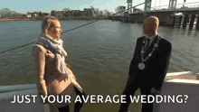 a man and a woman are standing next to a body of water and the man is asking the woman just your average wedding ?