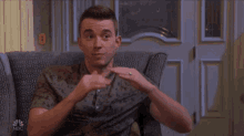 a man sitting in a chair with a nbc logo on the bottom