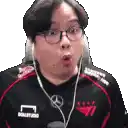 a man wearing glasses and headphones is making a funny face while sitting in a chair .