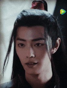 a close up of a man with long black hair