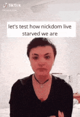 a woman with short hair is wearing a black shirt and choker necklace .