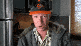 a man wearing an orioles hat and a gray jacket