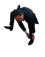 a man in a suit is bending over to put on his shoes