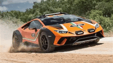 a red and black sports car is driving down a dirt road .