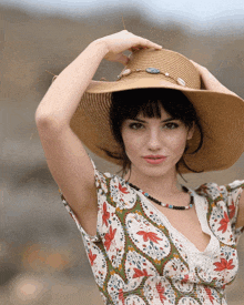 a woman wearing a floral dress and a hat