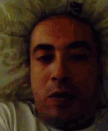 a close up of a man 's face laying on a bed
