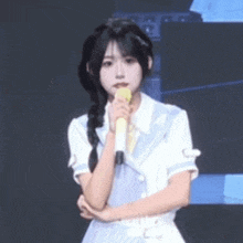 a young woman is holding a microphone in her hand .