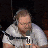 a man wearing headphones and glasses is holding a microphone with the number 8 on it