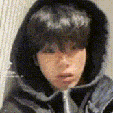 a close up of a person wearing a black jacket with a hood .