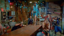 a group of people are standing around a table in a room with a sign that says open