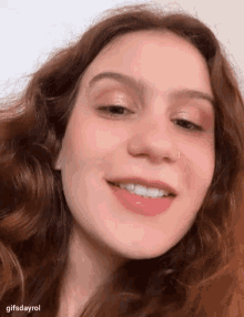 a woman with red hair and a nose ring smiles
