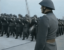 a man in a helmet stands in front of a military parade