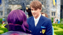 a man in a suit and tie is standing next to a woman in purple wig .