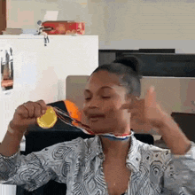 a woman is wearing a gold medal around her neck .