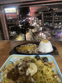 a plate of food sits in front of a window with a sign that says aguilat