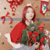 a woman with red hair is holding a christmas wreath and the letters ms are visible