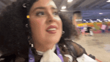a woman with curly hair is wearing a lanyard that says ' sd ' on it