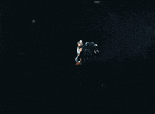 a woman with wings is flying through the air in the dark