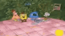spongebob and patrick are sitting on a pink blanket on a table .