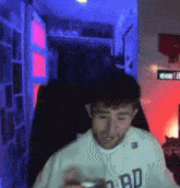 a man wearing a white gap sweatshirt is standing in a dark room