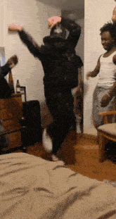 a group of people are dancing in a room and one of them is wearing a hat that says a&m