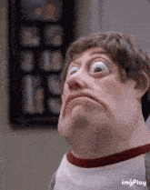 a close up of a man making a funny face with his eyes wide open .