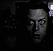a close up of a man 's face in the dark