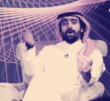 a man with a beard wearing a head scarf and a microphone