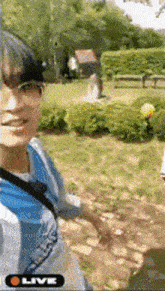 a man is taking a selfie in a park with a tennis ball .