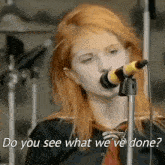a woman singing into a microphone with the words `` do you see what we 've done '' written below her .