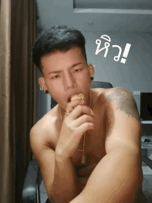 a shirtless man with a tattoo on his arm is eating