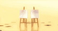 two easels with paintings on them are on a yellow background