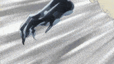 a close up of a person 's arm with a black claw