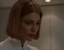 a close up of a woman 's face in a white shirt