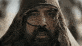 a man with a beard wearing a scarf around his head