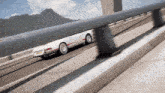a white porsche is driving on a bridge with a license plate that says ' nc ' on it
