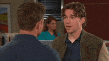 two men are talking to each other in a hospital room