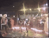 a group of people are dancing on a stage in a club .