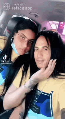 a man and a woman are sitting in a car . the woman is wearing a mask .