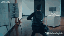 a man is walking through a museum with a youtube originals logo in the corner